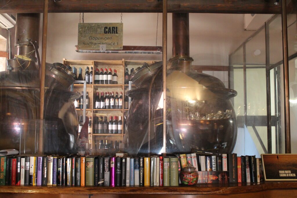 Le caldaie di rame della vecchia birreria dietro al vetro, con la cantina dei vini